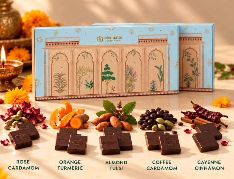 The blue Ananda Diwali box with its five bars, each beside its spices: rose and cardamom, orange and turmeric, almond and tulsi, coffee and cardamom, cayenne and cinnamon.